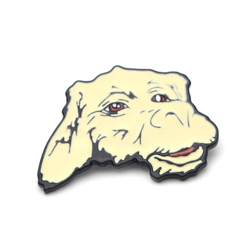 An enamel pin in the shape of Falkor's head. Falkor is a Luckdragon from The Neverending Story Movie.